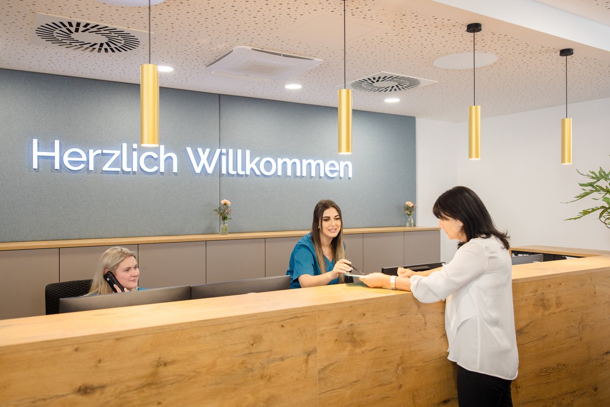 Patientin mit Arzthelferin beim Empfang