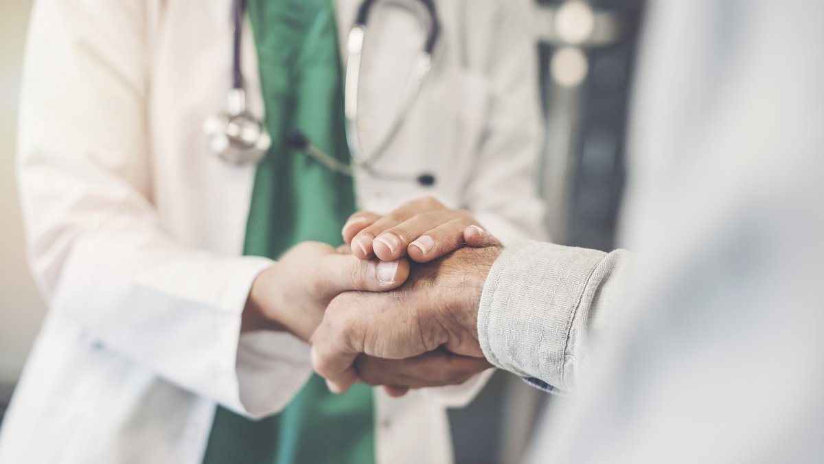 Arzt hält Patient die Hand